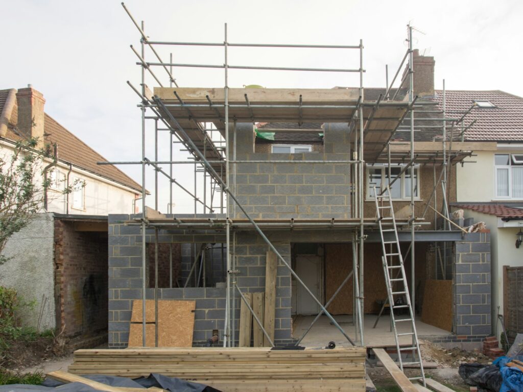 UK house extension under construction with scaffolding and blockwork